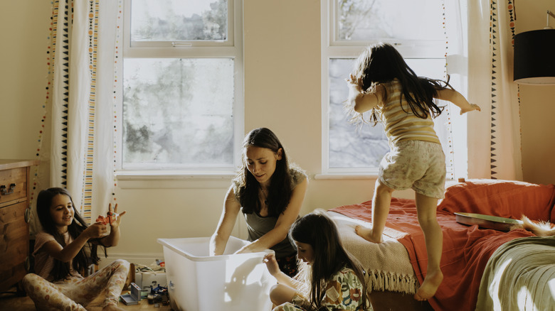 Une maman jouant avec des enfants avec des jouets sur le sol