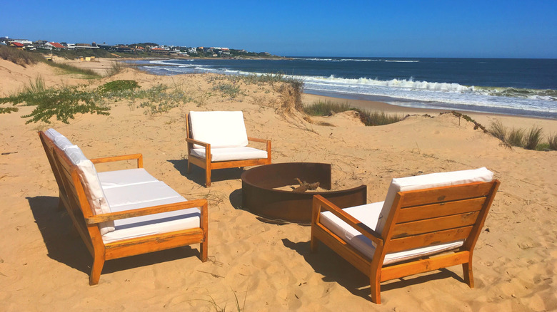 Chaises en bois et foyer sur la plage de José Ignacio