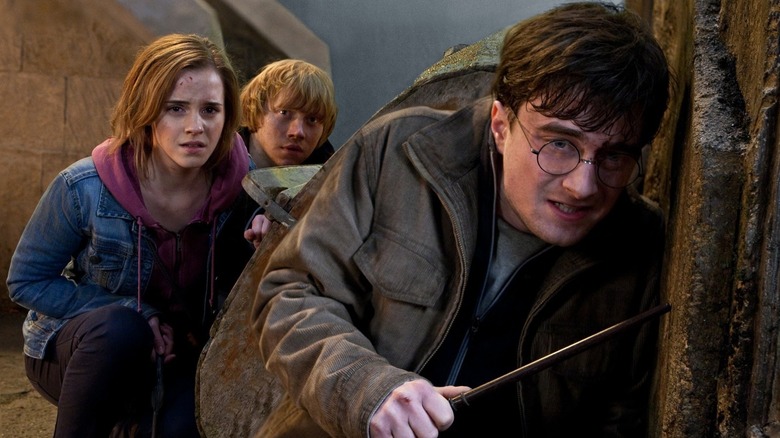 Ron, Hermione et Harry entourant un coin effrayé dans Harry Potter et les reliques de la mort: Partie 2