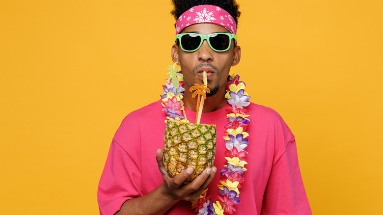 Touriste avec un lei sirotant une boisson à l'ananas