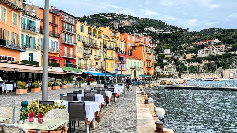 Bâtiments colorés et tables à manger près de l'océan.