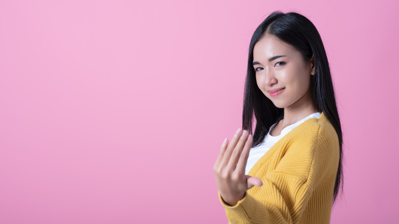 Jeune femme fait signe de la main