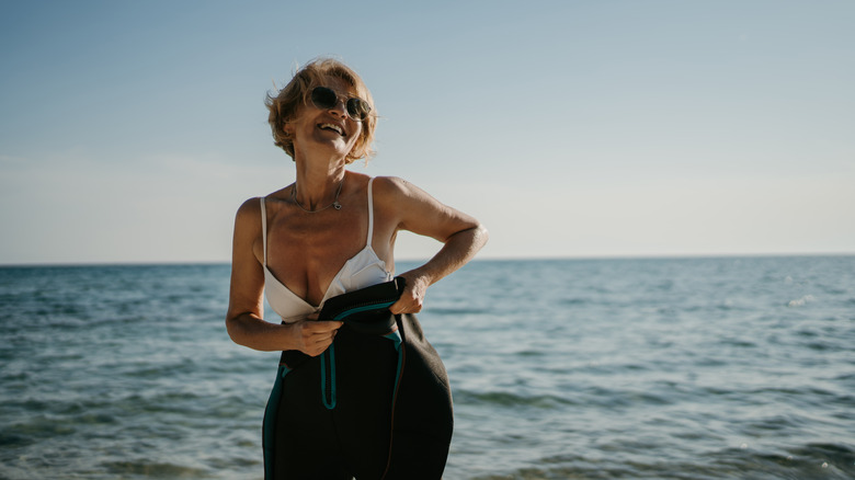 Femme souriante mettant la combinaison