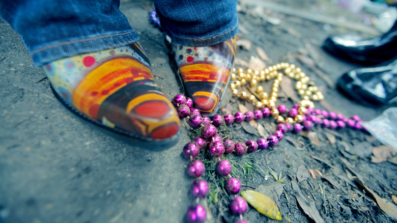 Des bottes colorées debout à côté des perles de mards gras dans la rue à la Nouvelle-Orléans