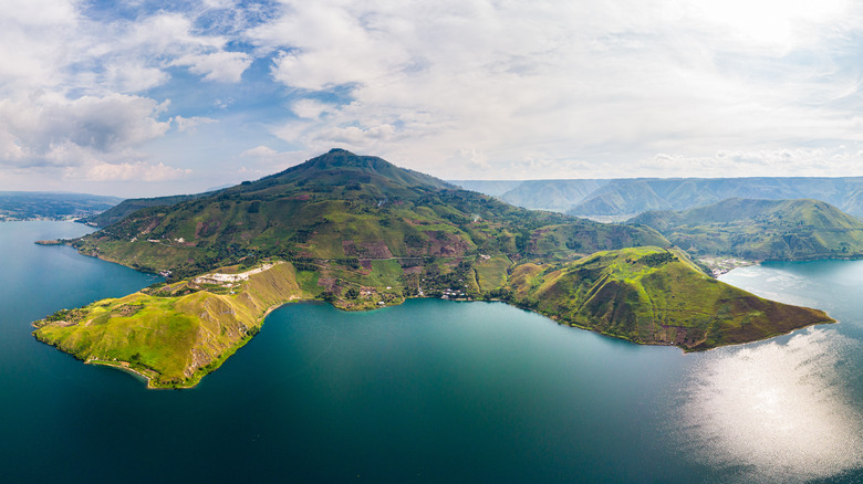 Une vue aérienne d'un lac entouré par des collines vertes et des vallées