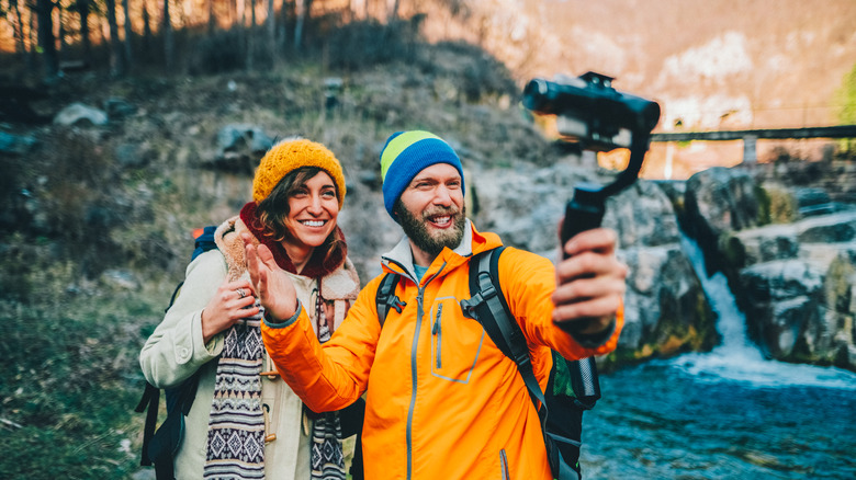 Un homme et une femme posent pour un selfie dans les bois