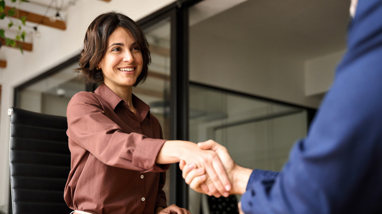 Femme et ma salut professionnellement avec une poignée de main