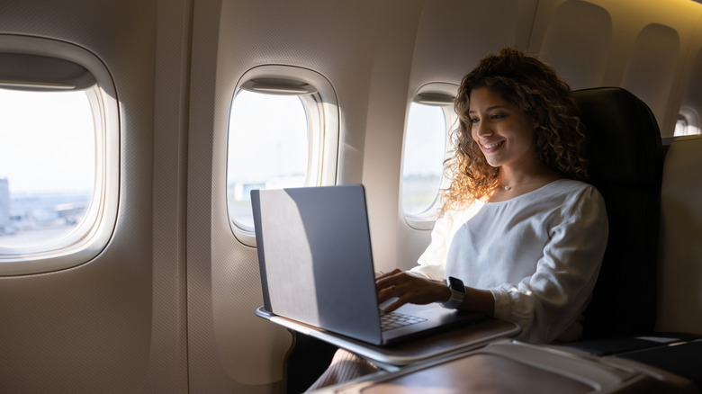 Une femme utilise un ordinateur portable sur un vol.