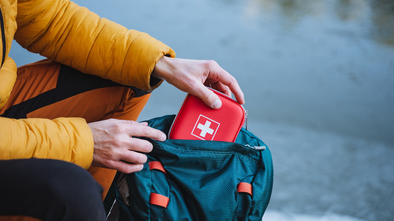 Randonneur ajoutant une trousse de premiers soins à la randonnée