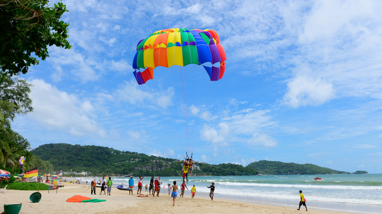 Un parasail décolle dans une plage en Thaïlande