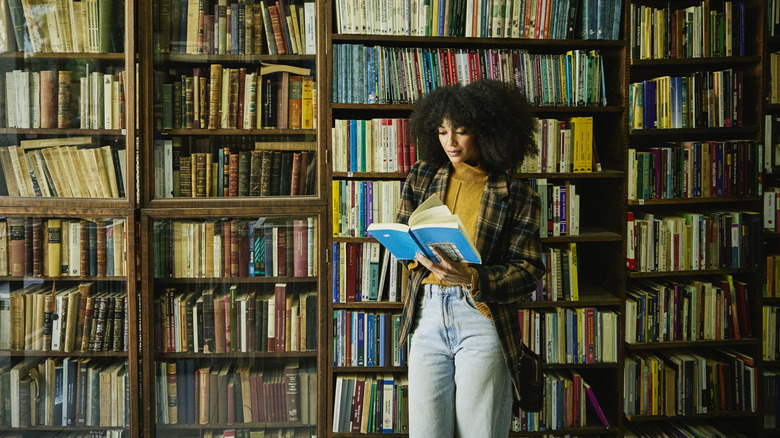 Livre de lecture de femme dans la bibliothèque