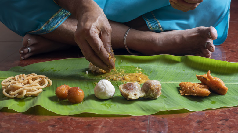 Une femme mange de la nourriture sur une feuille de bananier en Inde