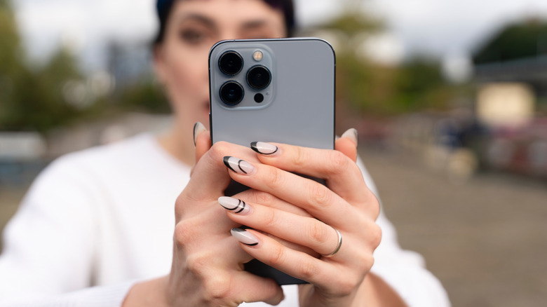 Une femme prenant une photo avec iPhone en extérieur