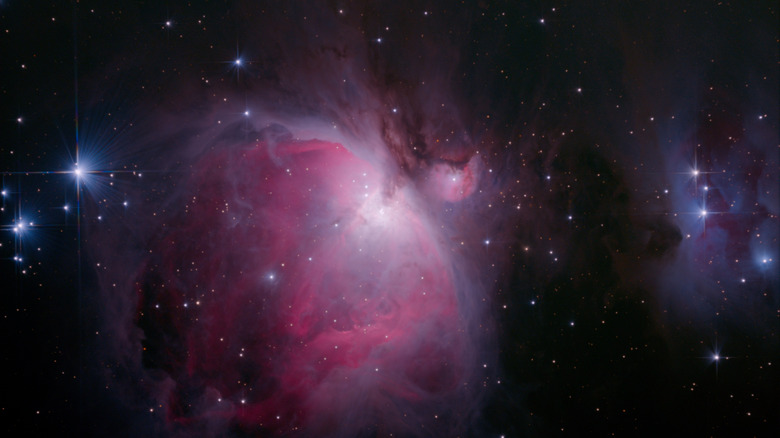 Un nuage de gaz rose et des étoiles en forme de diamant dans le ciel nocturne