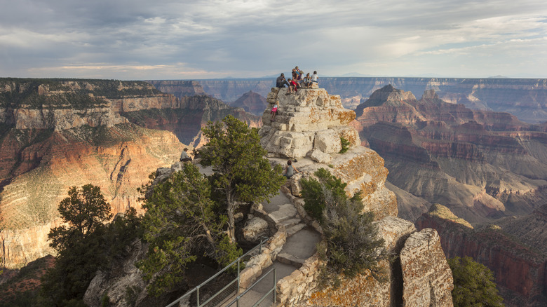 Randonneurs au sommet des formations rocheuses regardant à travers le Grand Canyon de Bright Angel Point North Rim