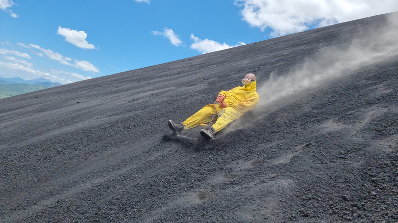 Une personne monte un sable dans les cendres volcaniques de Cerro Negro