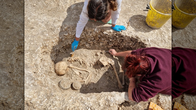 BU Personnel / Étudiants travaillant sur la tombe de l'âge du fer avec des restes et des objets de valeur