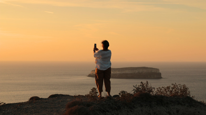 Voyageur en solo photographier le coucher du soleil de Santorin