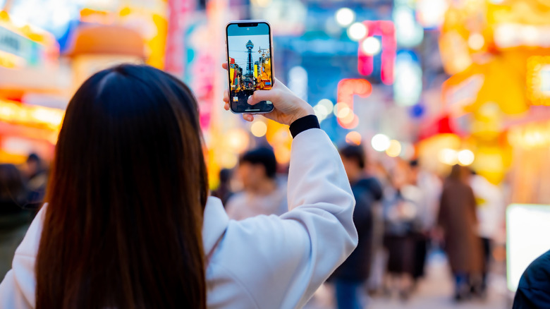 Femme prenant une photo dans un endroit bondé