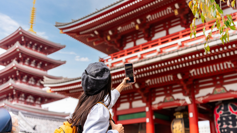 Femme prenant une photo au temple japonais