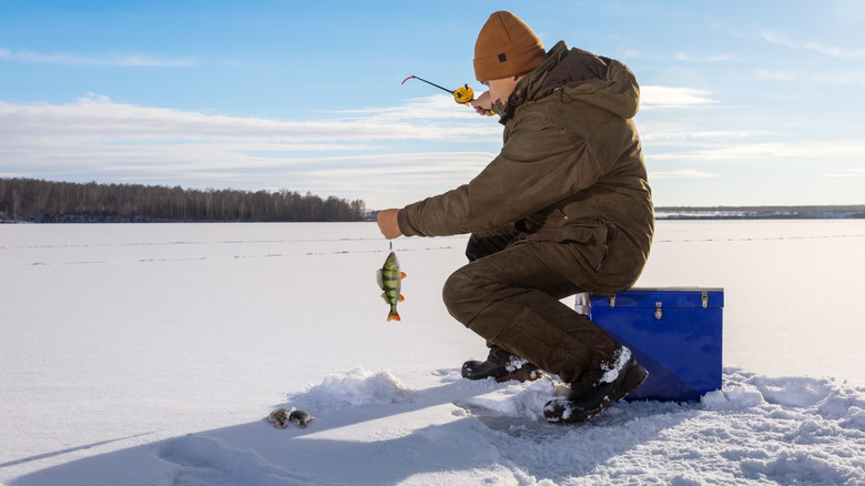 Pêcheur à la pêche à la glace sur un lac en hiver