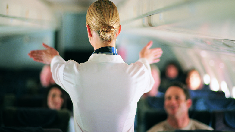 Des gestes de préposés en flight vers les passagers de la cabine d'avion