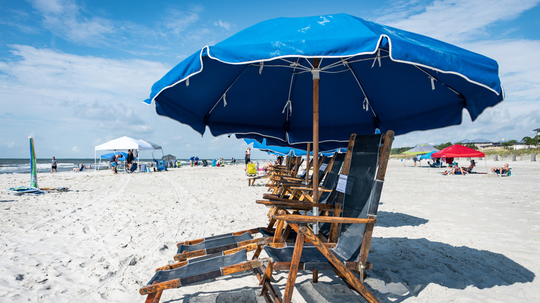 Chaises de plage avec parapluie sur du sable blanc à Coligny Beach Park