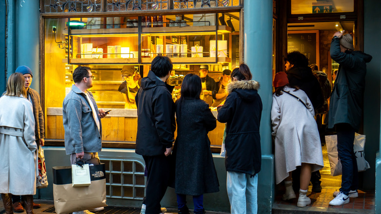 Les gens qui font la queue à l'extérieur de l'alimentation