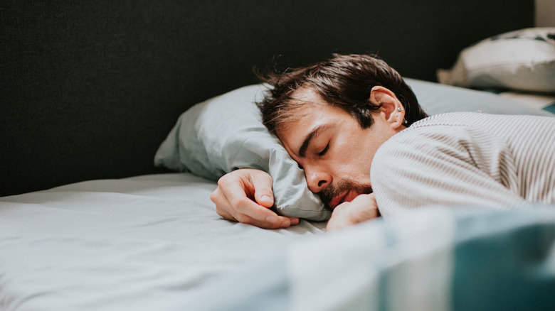 Un homme est allongé dans un lit endormi