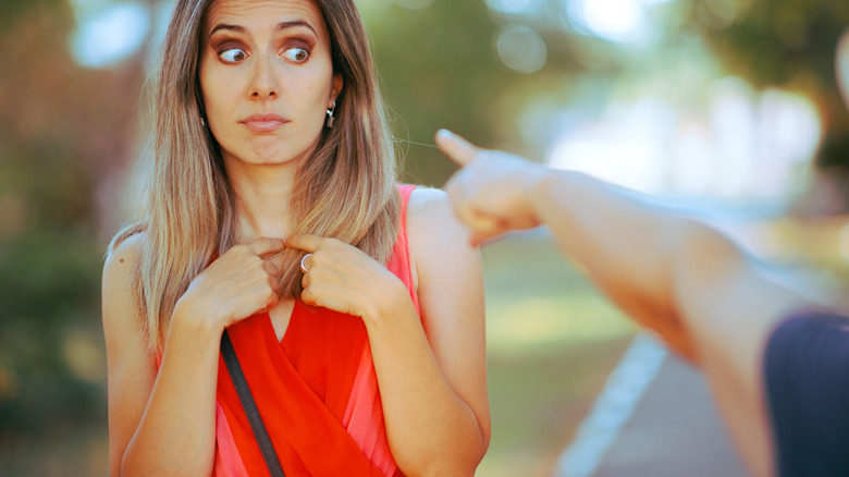 La main pointée de manière agressive sur la femme