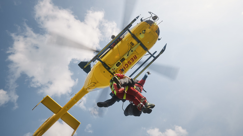 Les ambulanciers paramédicaux suspendus à un hélicoptère de sauvetage