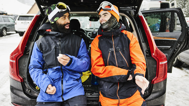 Deux skieurs reposant par leur voiture