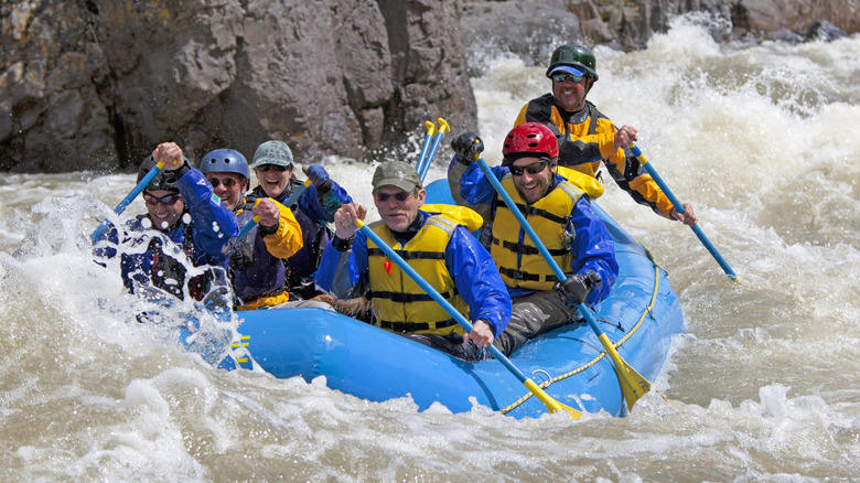 Un groupe d'hommes naviguez sur les rapides intenses de la rivière Whitwater dans un radeau