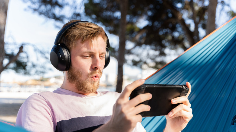 Personne jouant au jeu sur une console de jeu portable