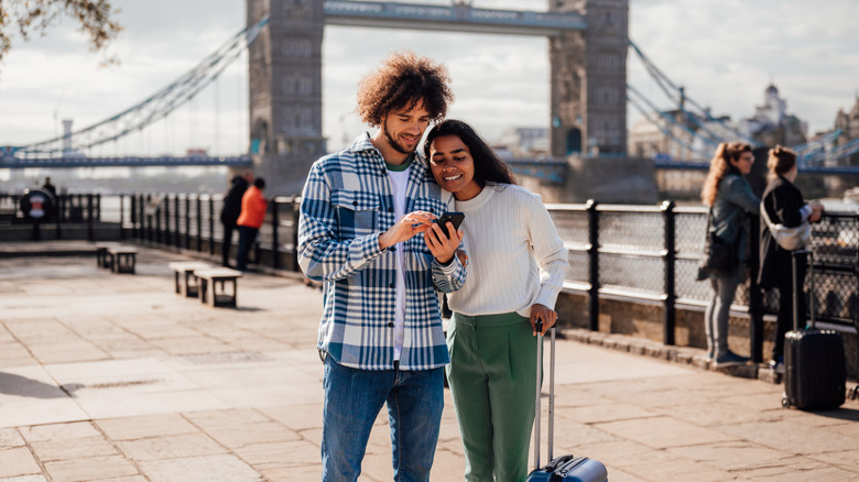 Couple de voyage en utilisant le téléphone