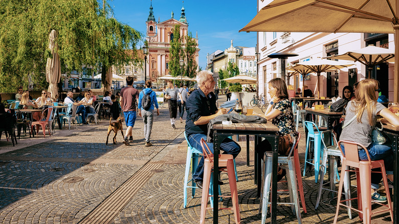 personnes à des tables à l'extérieur près des bâtiments historiques