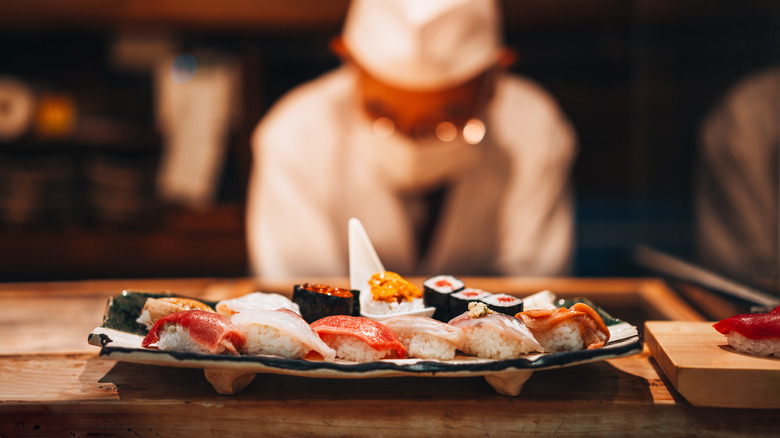 Un chef examine une assiette de sushi nigiri