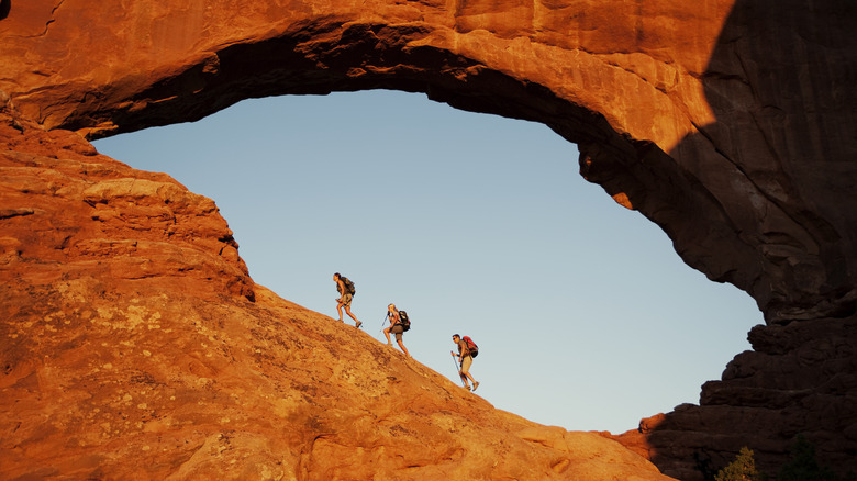 Les randonneurs montent un escarpement dans le parc national des arches, Utah