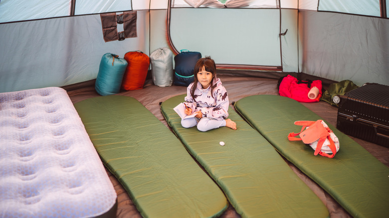 Kid mignon avec de nombreux coussinets de couchage