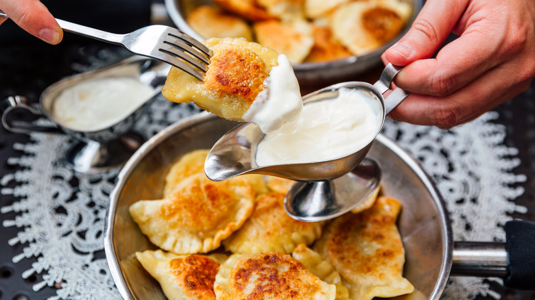 Une assiette de perrorogies servies avec de la crème sure