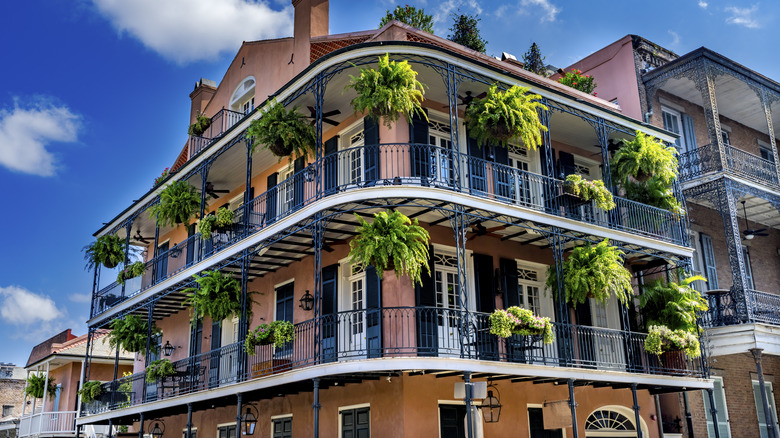 Bâtiment orange avec des fougères, des revêtements en fer forgé