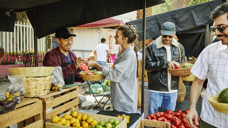 Femme qui paie sur un marché de producteurs
