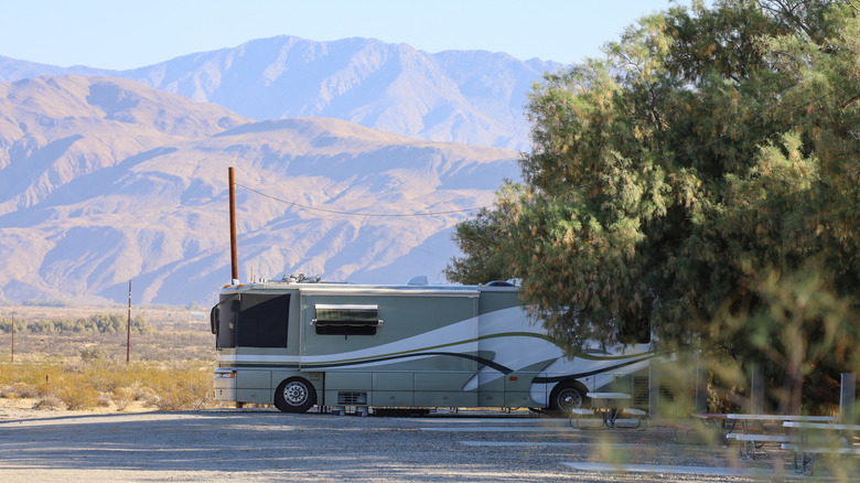 Grand camping-car garé avec des montagnes en toile de fond