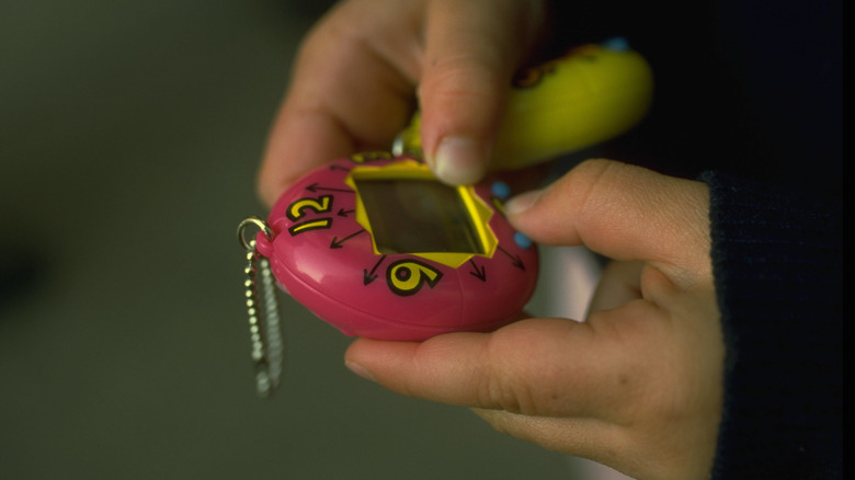 Tamagotchi joue des mains numériques animales numériques