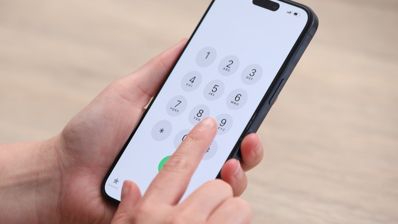 Personne composant un numéro sur un téléphone portable