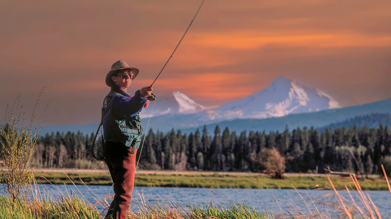 Un Fly-Fistherman jette une ligne avec les trois sœurs en arrière-plan, Oregon