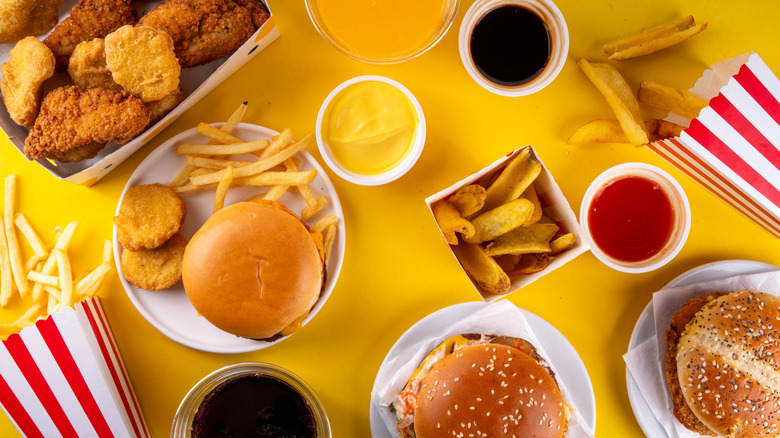 Burgers, frites et autres fast-food sur une table jaune