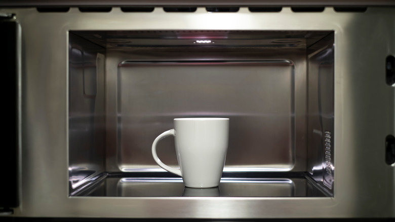 tasse à l'intérieur d'un four à micro-ondes en acier inoxydable