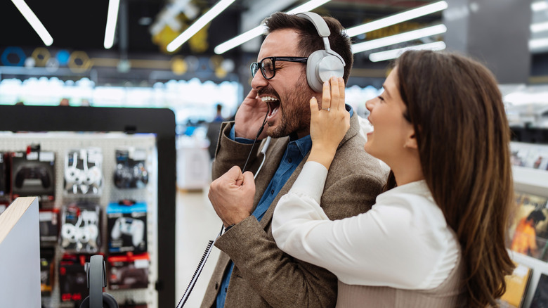 Les gens qui essaient des écouteurs en magasin