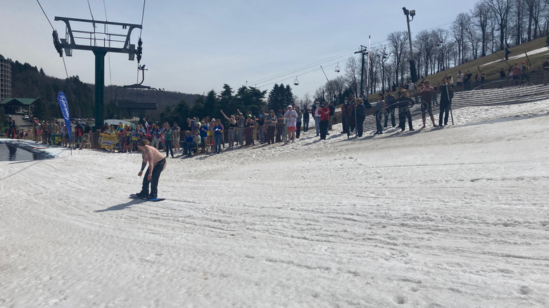 Torse nu ski avec une foule qui regarde